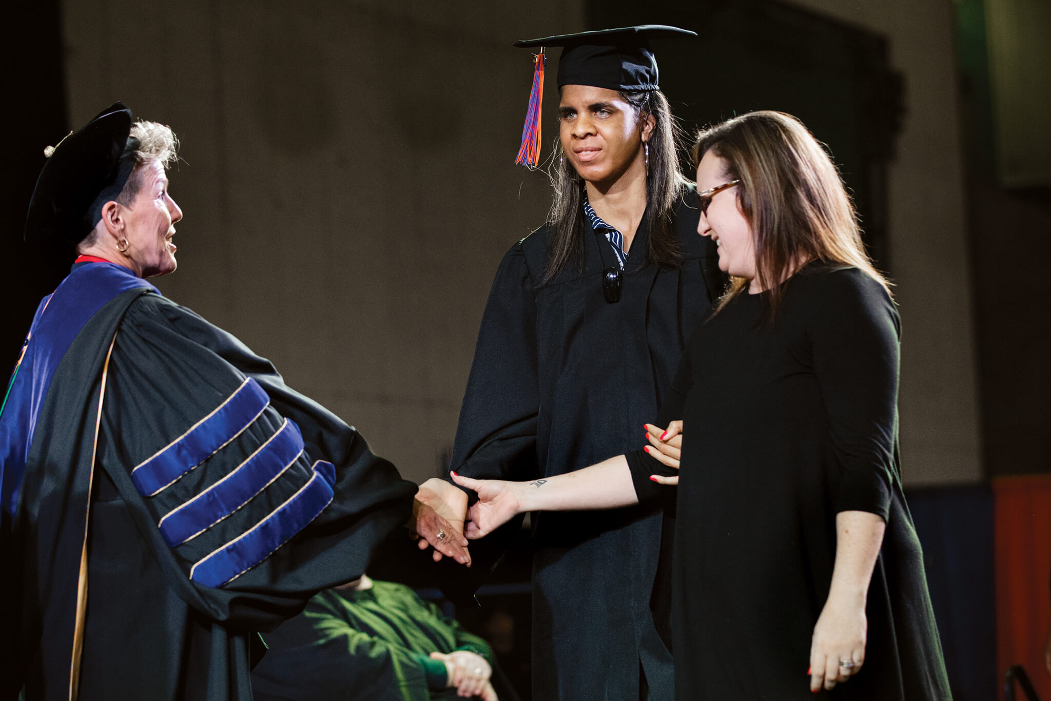 Ashley Jackson (center), of Jackson), crossed the commencement stage Dec. 15 to receive her bachelor’s degree from the University of Tennessee at Martin. Jackson is a deaf-blind student and plans to use her degree to assist children and families with various disabilities. She is pictured shaking the hand of  with the assistance of Lisa Cepparulo, an American Sign Language interpreter from the Jackson Star Center. Cepparulo and two other interpreters have worked with Jackson throughout her time at UT Martin.