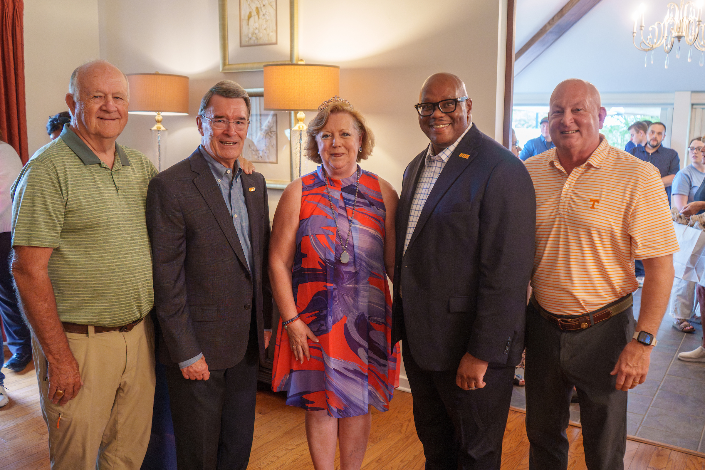 Five people are posed at a reception.