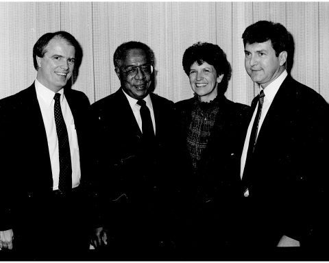 Four people are standing for a photo at an event