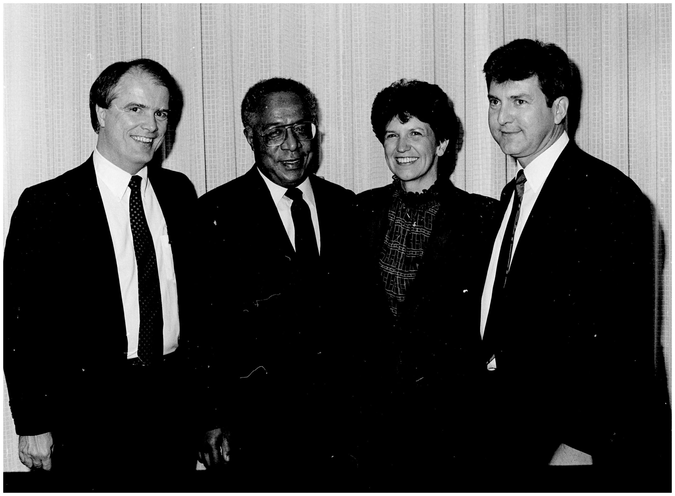 Four people are standing for a photo at an event