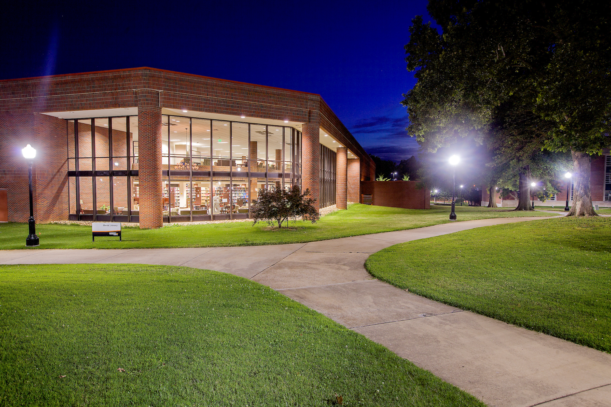 The outside of a college library is shown at night